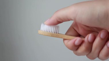 Woman hands holding wooden bamboo toothbrush, sustainable lifestyle, zero waste concept.