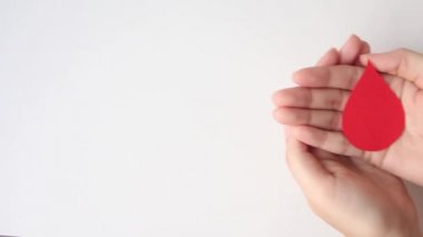 Beyaz arka planda kağıttan yapılmış el ele tutuşmalar, fotokopi alanı, üst görünüm. Kan bağışı konsepti, dünya kan bağışı günü.