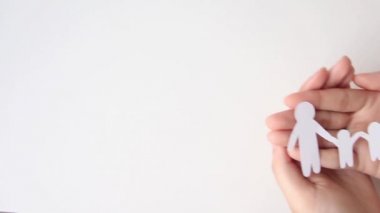 hands holding paper family cut out, family home.