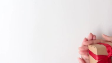 woman hands holding a small gift box on white background.