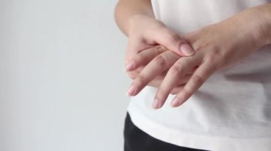 Ellerindeki acıdan muzdarip genç bir kadın ve acı çeken ellerine masaj yapıyor. Karpal tünel sendromu, kırıklar, eklem iltihabı veya tetik parmağı, çevresel nöropati.