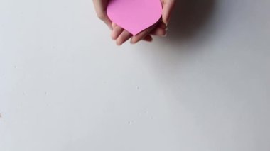 Hand holding pink heart on white background, healthcare, organ donation, love, hope and giving concept.