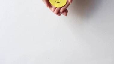 Woman hands holding yellow smile face paper, good feedback rating,think positive, customer review, assessment, world mental health day, Compliment Day.