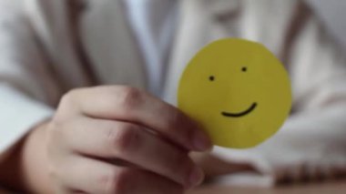 Woman hands holding yellow smile face paper, good feedback rating,think positive, customer review, assessment, world mental health day, Compliment Day.