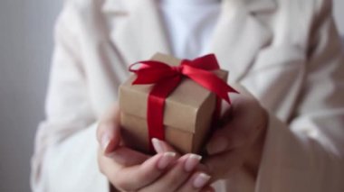 Beyaz arka planda kırmızı kurdeleli bir kadın el ele tutuşuyor..