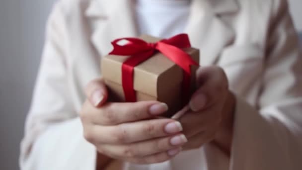 Vrouw Hand Holding Geschenkdoos Met Rood Lint Witte Achtergrond — Stockvideo