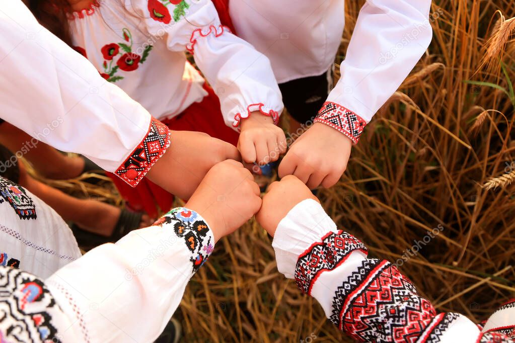 The hands of children in embroidered shir are joineded in a welcoming gesture. The united hands symbolize unity. Independence Day of Ukraine, Constitution, Embroidery