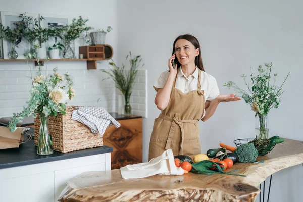 Yeşil malzemeleri ve baharatlı otları olan güzel bir kadın mutfakta sağlıklı yemek pişiriyor. Sağlıklı ve sağlıklı olma kavramı