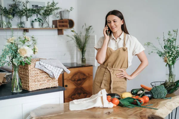 Mulher bonita com ingredientes verdes e ervas picantes cozinhar alimentos saudáveis na cozinha. Conceito de saúde e bem-estar — Fotografia de Stock