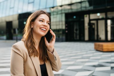 Açık havada otururken telefonla arıyor çekici Bayan portresi