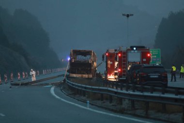Bosnek, Bulgaristan - 23 Kasım 2021: İtfaiyeciler Bosnek köyü yakınlarındaki bir otoyolda meydana gelen otobüs kazasını inceliyor. Kuzey Makedonya 'ya turist taşıyan bir otobüs, sabahın erken saatlerinde Bulgaristan' ın batısında kaza yaparak 45 kişinin ölümüne yol açtı.