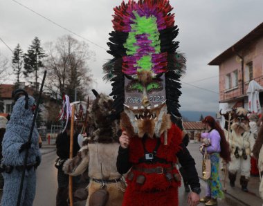 Bulgaristan 'ın Godech kenti - 1 Ocak 2022: Geleneksel kostümlü mumyalar 2022 yılının ilk gününde Godech sokaklarını gezdiler. Kukeri isimli maskeli insanlar dans ediyor ve kötü ruhları korkutmak için gösteri yapıyorlar.