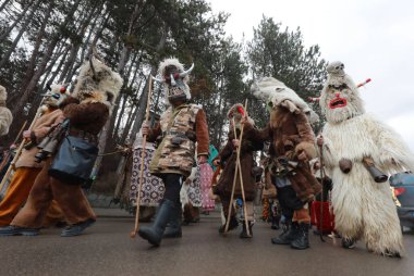 Bulgaristan 'ın Godech kenti - 1 Ocak 2022: Geleneksel kostümlü mumyalar 2022 yılının ilk gününde Godech sokaklarını gezdiler. Kukeri isimli maskeli insanlar dans ediyor ve kötü ruhları korkutmak için gösteri yapıyorlar.
