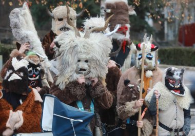 Bulgaristan 'ın Godech kenti - 1 Ocak 2022: Geleneksel kostümlü mumyalar 2022 yılının ilk gününde Godech sokaklarını gezdiler. Kukeri isimli maskeli insanlar dans ediyor ve kötü ruhları korkutmak için gösteri yapıyorlar.