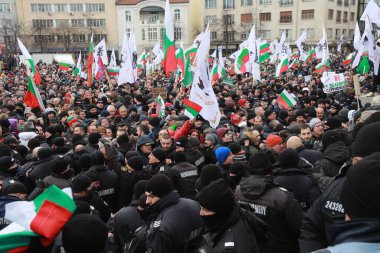 Sofia, Bulgaria - January 12, 2022: Police officers resist people during a protest against green certificate and vaccination against COVID-19 in fort of Bulgarian Parliament in Sofia. 