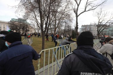 Sofia, Bulgaria - January 12, 2022: Police officers resist people during a protest against green certificate and vaccination against COVID-19 in fort of Bulgarian Parliament in Sofia. 
