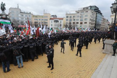 Sofia, Bulgaria - January 12, 2022: Police officers resist people during a protest against green certificate and vaccination against COVID-19 in fort of Bulgarian Parliament in Sofia. 