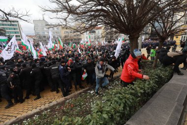 Sofia, Bulgaria - January 12, 2022: Police officers resist people during a protest against green certificate and vaccination against COVID-19 in fort of Bulgarian Parliament in Sofia. 
