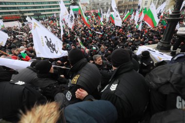 Sofia, Bulgaria - January 12, 2022: Police officers resist people during a protest against green certificate and vaccination against COVID-19 in fort of Bulgarian Parliament in Sofia. 