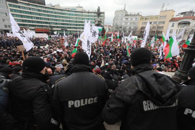 Sofia, Bulgaria - January 12, 2022: Police officers resist people during a protest against green certificate and vaccination against COVID-19 in fort of Bulgarian Parliament in Sofia. 