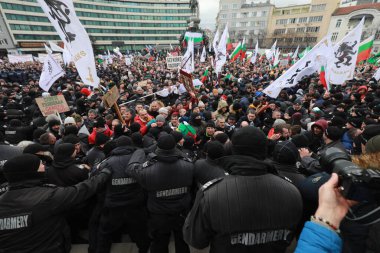 Sofia, Bulgaria - January 12, 2022: Police officers resist people during a protest against green certificate and vaccination against COVID-19 in fort of Bulgarian Parliament in Sofia. 