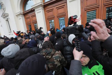 Sofia, Bulgaria - January 12, 2022: Police officers resist people during a protest against green certificate and vaccination against COVID-19 in fort of Bulgarian Parliament in Sofia. 