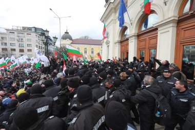 Sofia, Bulgaria - January 12, 2022: Police officers resist people during a protest against green certificate and vaccination against COVID-19 in fort of Bulgarian Parliament in Sofia. 