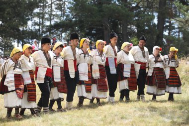 Koprivshtica, Bulgaria - August 6, 2022: People in traditional folk costume of The National Folklore Fair in Koprivshtica. The National Folklore Fair in Koprivshtica is entered in the UNESCO Register of the human intangible cultural heritage