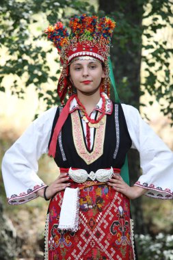 Koprivshtica, Bulgaria - August 6, 2022: People in traditional folk costume of The National Folklore Fair in Koprivshtica. The National Folklore Fair in Koprivshtica is entered in the UNESCO Register of the human intangible cultural heritage