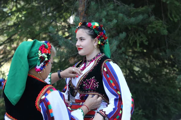 Koprivshtica, Bulgaria - August 6, 2022: People in traditional folk costume of The National Folklore Fair in Koprivshtica. The National Folklore Fair in Koprivshtica is entered in the UNESCO Register of the human intangible cultural heritage