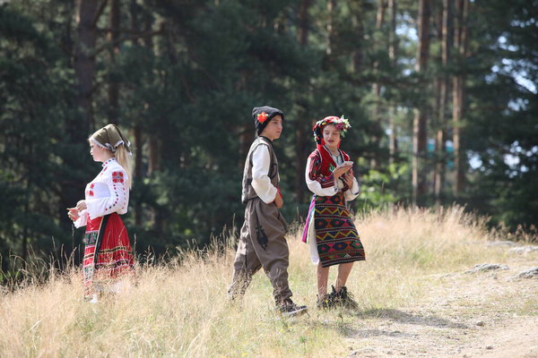 Копривштица, Болгария - 6 августа 2022 года: Люди в традиционном народном костюме Национальной фольклорной ярмарки в Копривштице. Национальная фольклорная ярмарка в Копривштице внесена в Реестр нематериального культурного наследия ЮНЕСКО