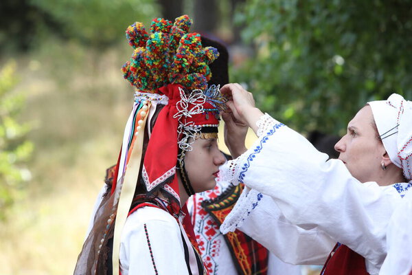 Копривштица, Болгария - 6 августа 2022 года: Люди в традиционном народном костюме Национальной фольклорной ярмарки в Копривштице. Национальная фольклорная ярмарка в Копривштице внесена в Реестр нематериального культурного наследия ЮНЕСКО