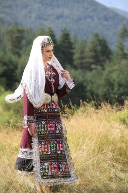 Koprivshtica, Bulgaria - August 6, 2022: People in traditional folk costume of The National Folklore Fair in Koprivshtica. The National Folklore Fair in Koprivshtica is entered in the UNESCO Register of the human intangible cultural heritage