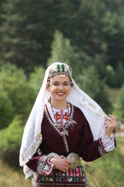 Koprivshtica, Bulgaria - August 6, 2022: People in traditional folk costume of The National Folklore Fair in Koprivshtica. The National Folklore Fair in Koprivshtica is entered in the UNESCO Register of the human intangible cultural heritage