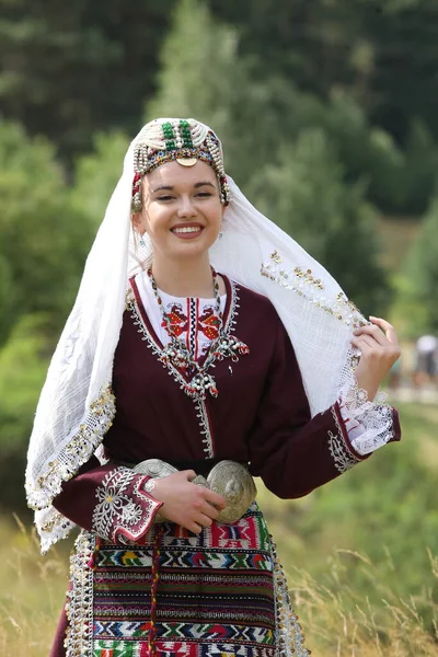 Koprivshtica, Bulgaria - August 6, 2022: People in traditional folk costume of The National Folklore Fair in Koprivshtica. The National Folklore Fair in Koprivshtica is entered in the UNESCO Register of the human intangible cultural heritage