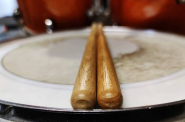 Yakın çekim davul sesleri ve tahta tokmaklar, arka planda bir davul seti, bir rock grubu, fotoğraf