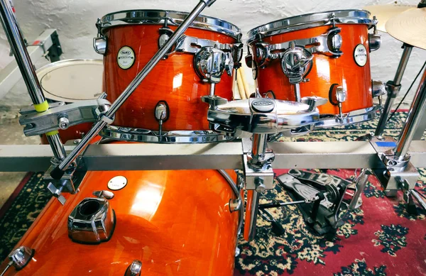 Prova odasındaki davul setinin yakın görüntüsü, turuncu geçiş davullarının ön görüntüsü, fotoğraf.