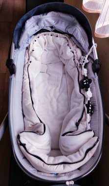 Çocuk odasında bulut şeklinde yastıkları olan bir bebek karyolası, yan görüş, fotoğraf.