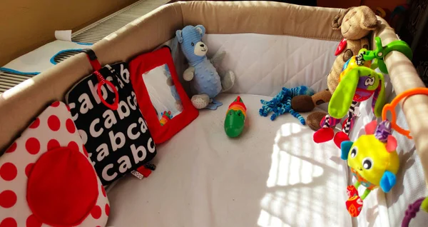 Bebek karyolası, bebek odasında bulut şeklinde yastıklar, yan görüş, peluş oyuncaklar, fotoğraf.