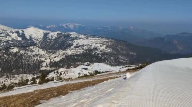 Kayak merkezinin manzarası, yamaçlarda kayak yapan kayakçılar, arka planda Tyrolean Alpleri, sağdan sola kamera hareketi