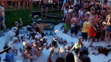 Pag, Zrce, Croatia, July 22, 2022: Close-up view of young people dancing to music in a pool full of foam, Namori dance club, summer party