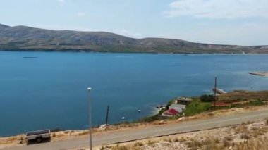 Pag adasının kıyısındaki evlere bakın, arka planda Pag adasının dağları ve tepeleri, yavaş çekim.