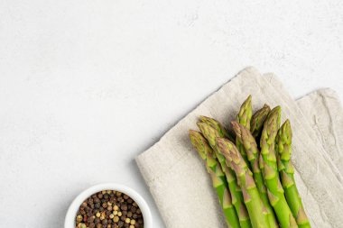 Gri arka planda peçete ve biber karışımı taze çiğ kuşkonmaz. Mükemmel garnitür. 