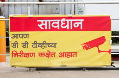 Esnek pankart, Hintçe 'de CCTV gözetlemesi yapan müşterileri uyarır.