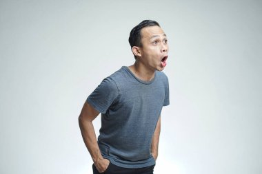 Stüdyonun arka planında Asyalı bir adam bağırıyor ve bağırıyor.