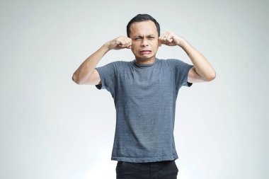 Stüdyoda yalnız başına ağlayan Asyalı adam.