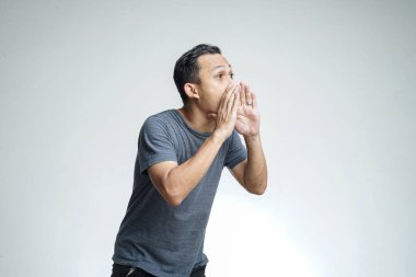 Stüdyonun arka planında koluyla bağıran Asyalı genç bir adamın portresini yakından çek.