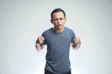 Kızgın Asyalı adam stüdyo arka planında izole edilmiş.