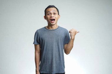 Asyalı adam göbeğini işaret ediyor. Stüdyo arka planında izole