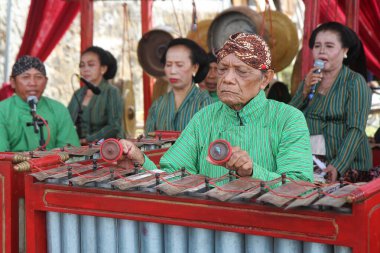 Gamelan müzik enstrümanı çalan geleneksel java kıyafetleri giyen yaşlı bir adam. Yogyakarta, 15 Eylül 2022